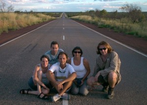 Gruppo di viaggiatori seduti in mezzo a una strada nel bush