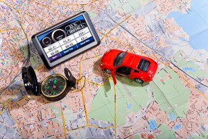 Mappa stradale con un'auto rossa giocattolo, una bussola e un navigatore
