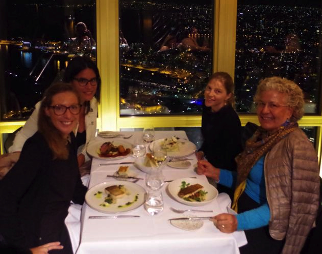 Four women at dinner above a city at night
