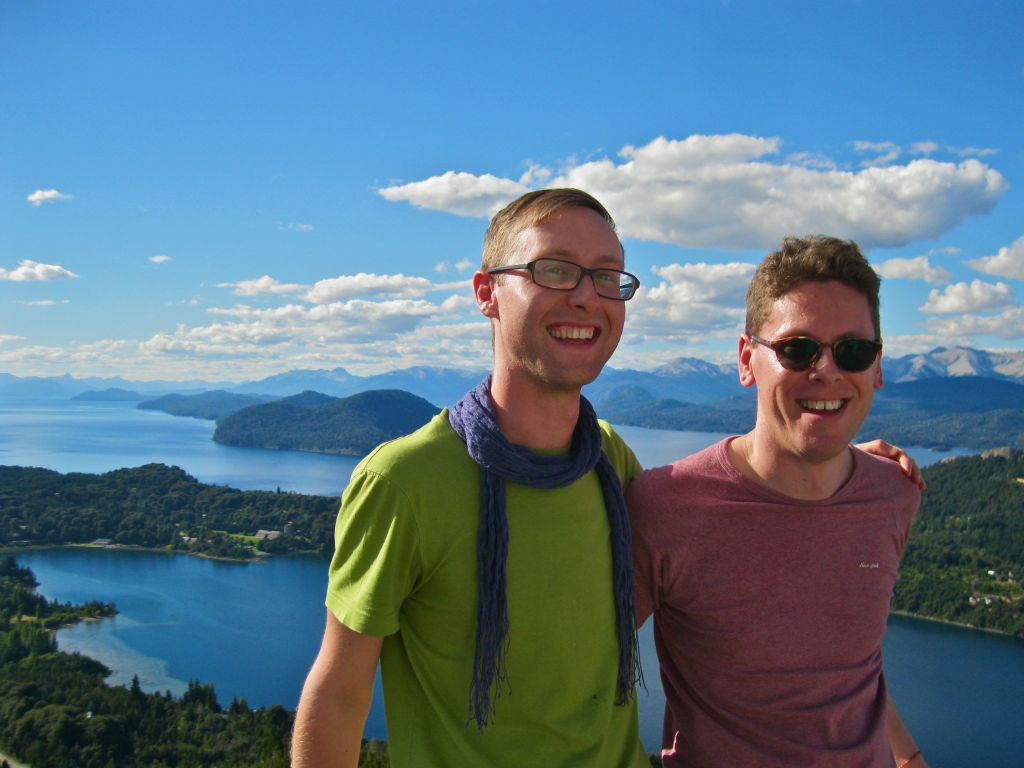 Two friends above a lake and mountains